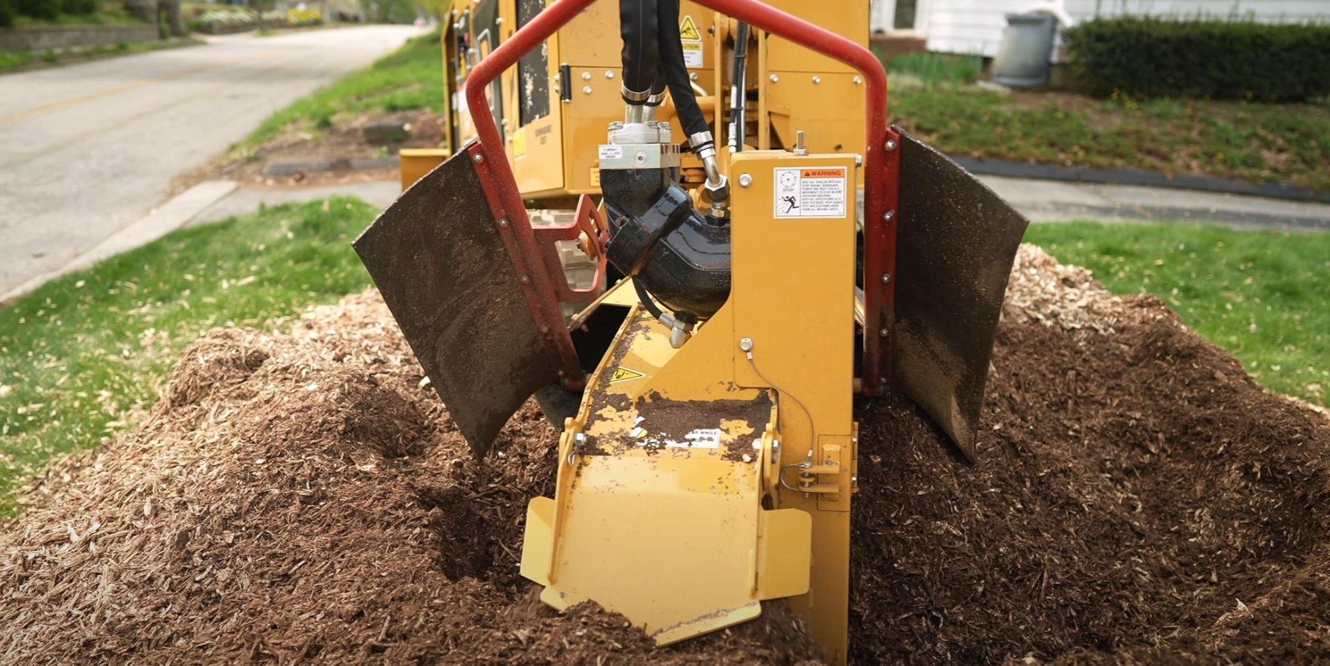 Stump grinding equipment - Professional machinery for efficient stump removal services Professional stump grinding equipment working in residential yard for complete stump removal